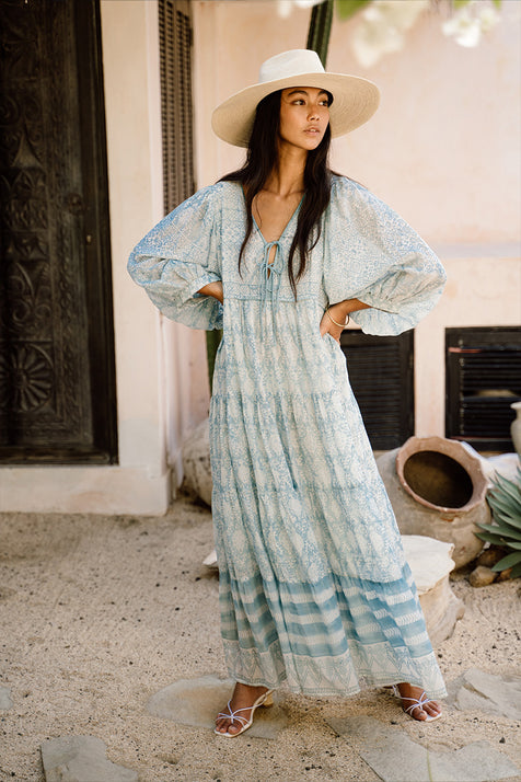 Jasmine Maxi Dress Sea Mist — outdoor lifestyle, model standing in garden doorway, full length flowing tiered skirt, hand block print sea mist blue cotton maxi, artisan Jaipur India | Daughters of India